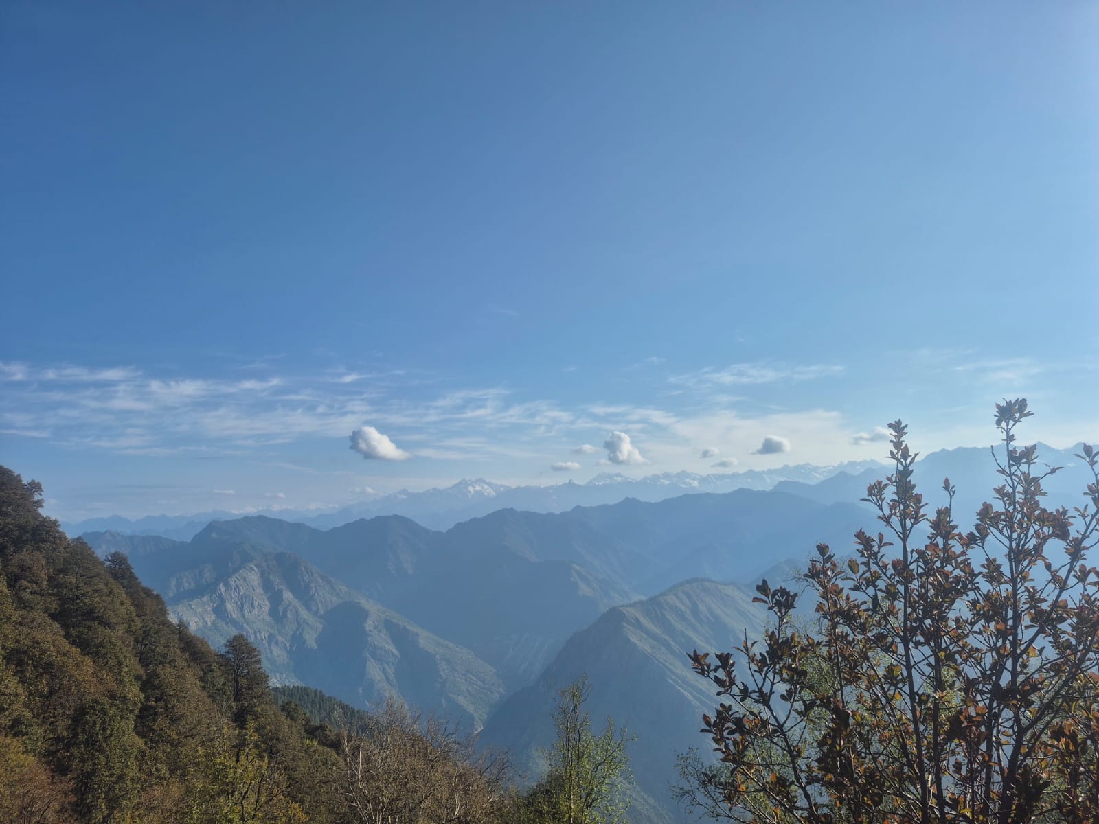 Layered Himalayan mountain ridges beneath a clear blue sky